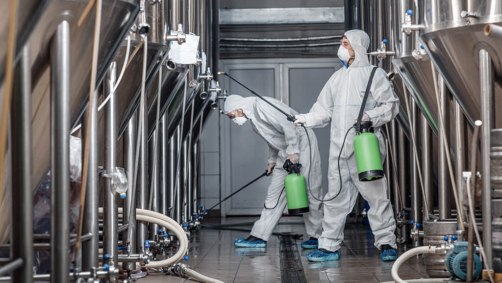 profissional-de-manutenção-espalhando-produto-de-limpeza-em-equipamento