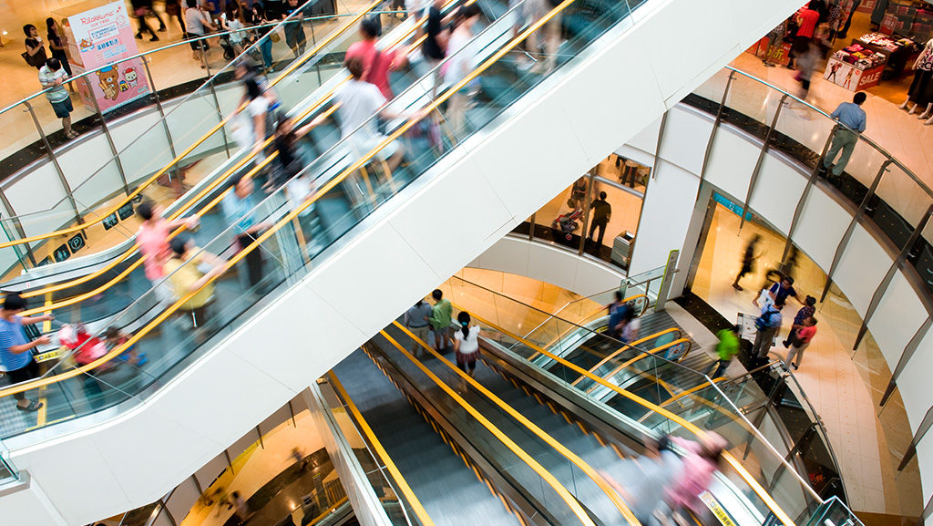 pessoas em escada rolante de shopping center